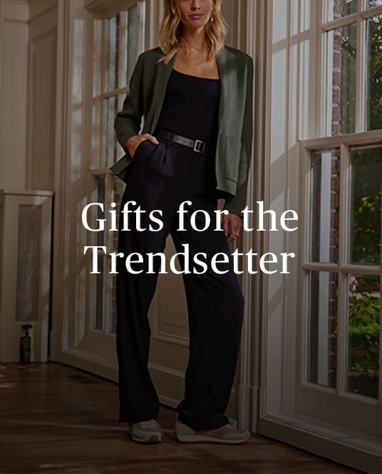 Gifts for the Trendsetter copy over an image of a woman leaning against a window wearing the Summersalt Ribbed Sweater Blazer in Olive