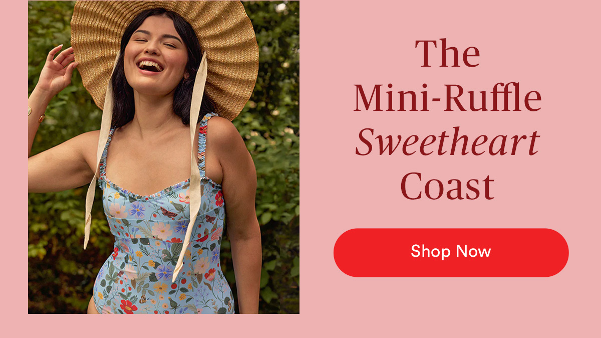 The Mini-Ruffle Sweetheart Coast. Woman posing in front of greenery wearing a hat and the Summersalt Mini-Ruffle Sweetheart Coast.