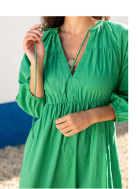 Woman wearing green dress with neck ruffle detail