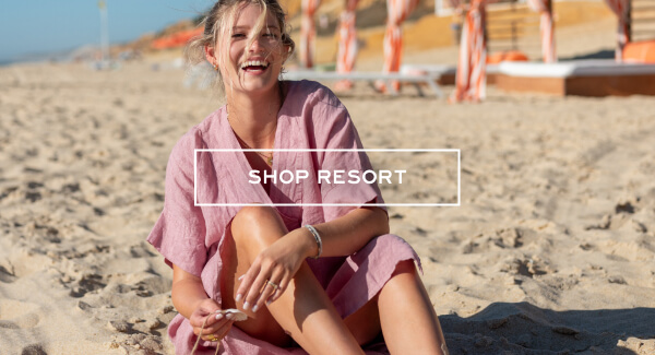 Shop Resort - Image of a woman sitting on a beach wearing a light pink coverup