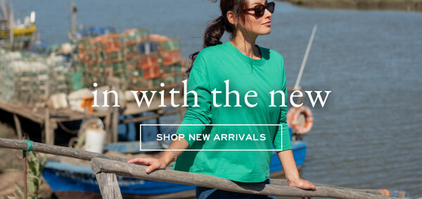 In with the new - Shop new arrivals - Image of a woman on a dock wearing a green long sleeve tee