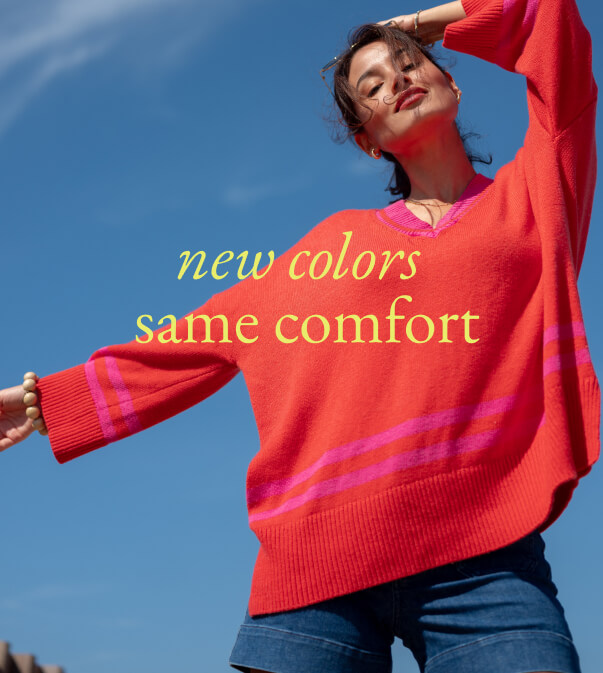 New Colors Same Comfort - Image of a woman wearing an orange v-neck sweater with pink stripes