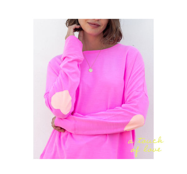 a touch of love - Image of a woman wearing a long sleeve pink tee with light pink heart patches on the elbows