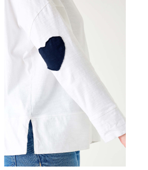 Close up of the side of a white long sleeve tee with a navy heart patch on the elbow