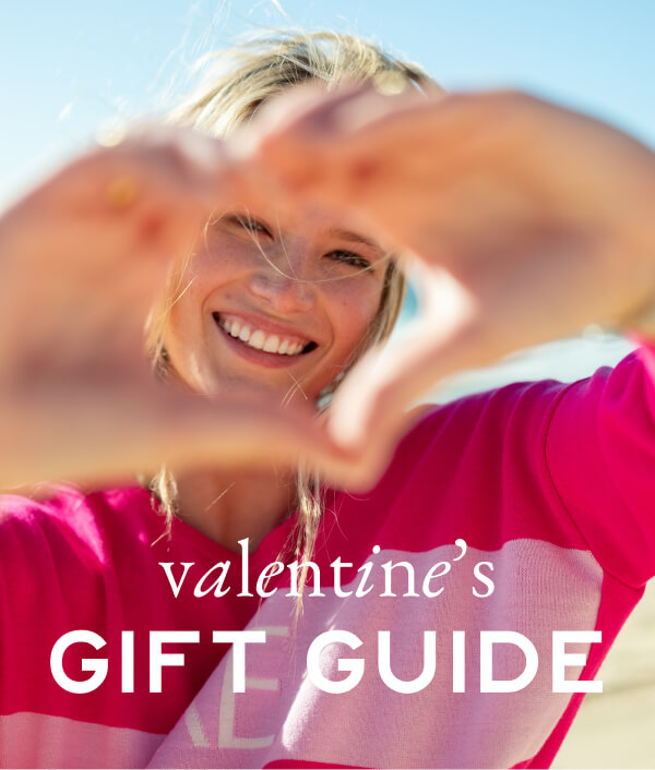 Valentine's Gift Guide - Image of a woman in a pink sweater making a heart shape with her hands