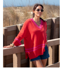 Image of a woman wearing an orange v-neck sweater with pink stripes on the hem