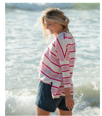 Image of a woman on the beach wearing a white and pink stripe v-neck sweater