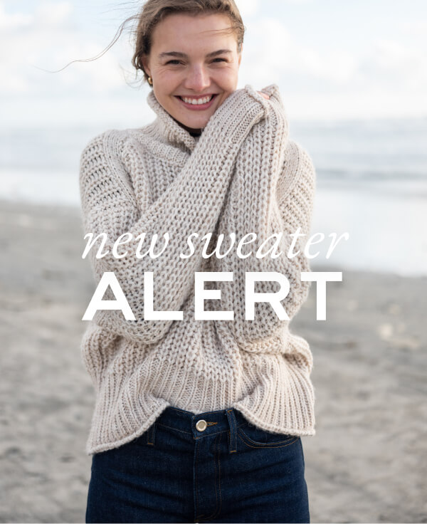 New Sweater Alert - image of woman on beach wearing turtleneck sweater