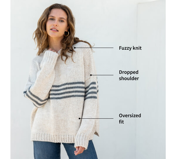 Detail shot of woman wearing cream sweater with stripes