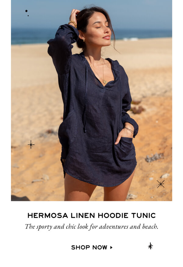 Hermosa Linen Hoodie Tunic - The sporty and chic look for adventures and beach. - Shop now - Image of a woman on the beach wearing a navy linen hoodie as a coverup