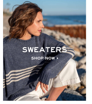 Sweaters - Shop now - Image of a woman sitting on a beach in a blue sweater with white stripes