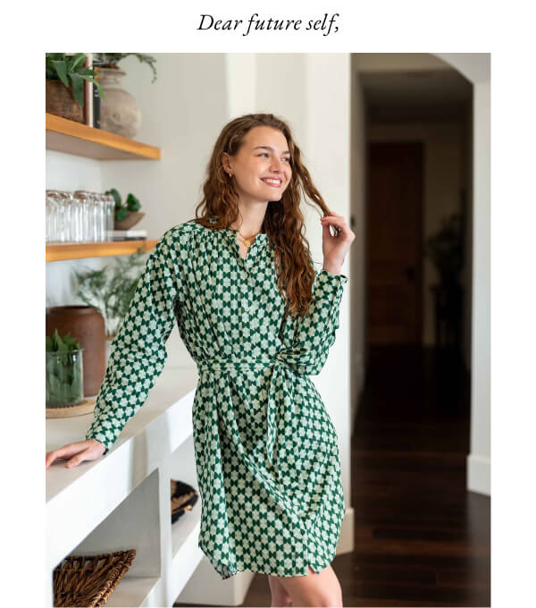 Dear future self, - Image of a woman wearing a geo printed green dress leaning up against a bar in her home