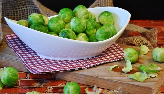A small white bowl filled with brussels sprouts on a table