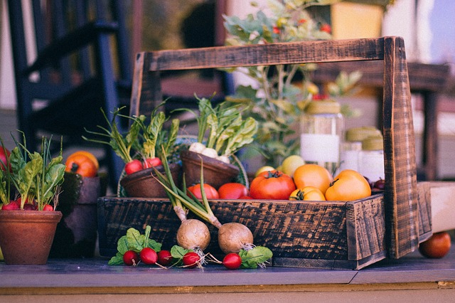 A wooden basket filled with vegetables: turnips, radishes, tomatoes, and beets