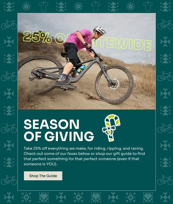 A mountain biker slides on a sandy hill wearing a pink jersey and black shorts