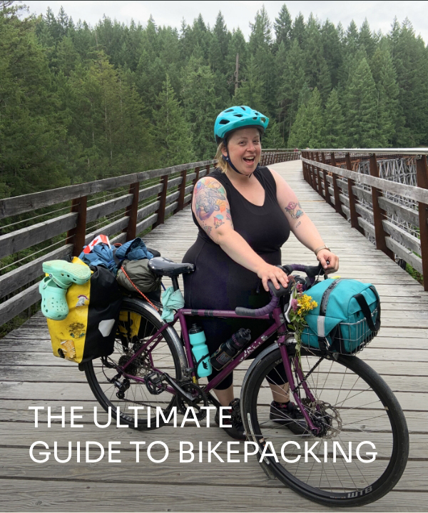 Athlete Marley Blonsky shows off her Bikepacking setup on a boardwalk in the forest.