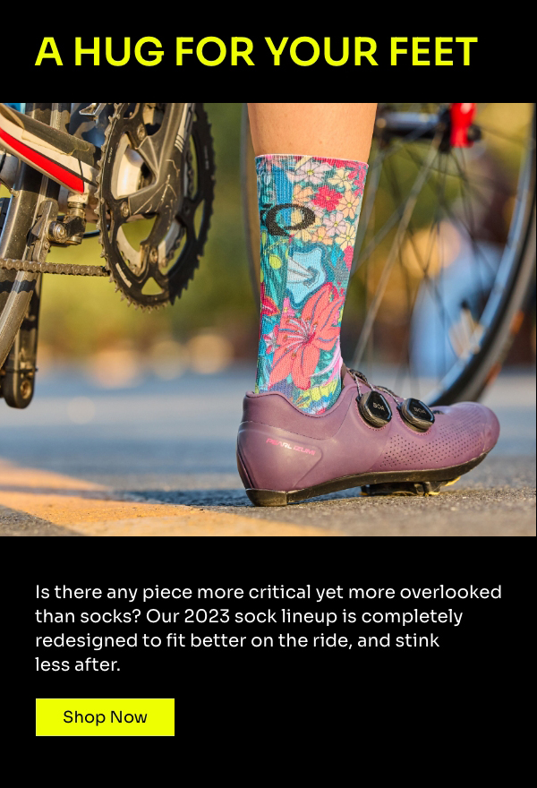 Cyclist's leg is visible wearing a floral sock and a purple road show