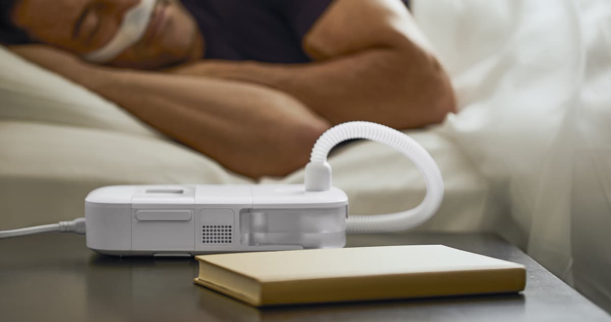 Man lying comfortably in bed using a CPAP machine