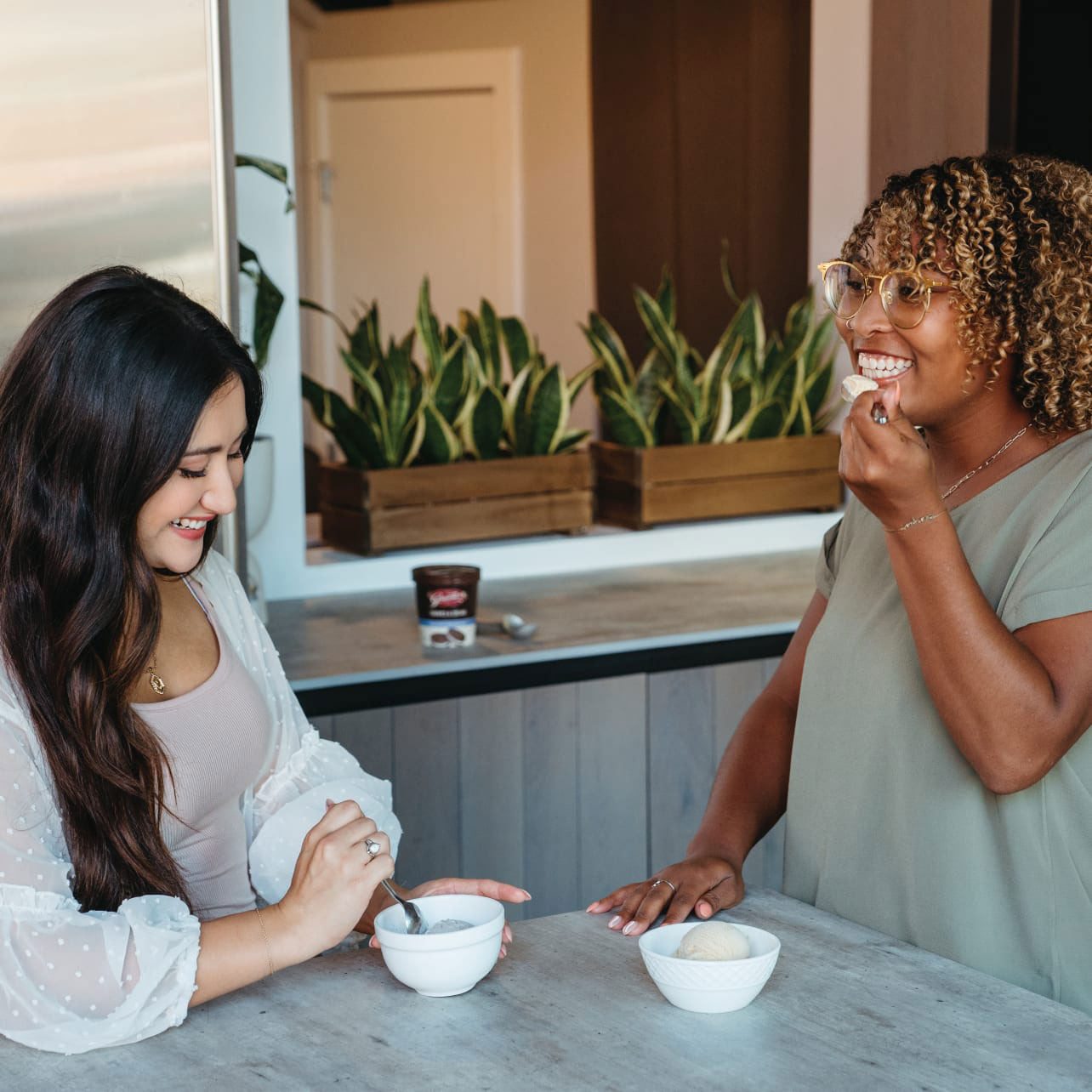 Two people enjoying ice cream on their kitchen table